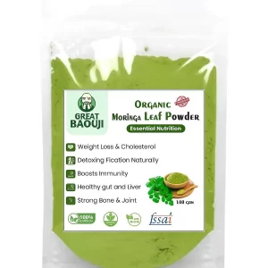 Package of organic moringa leaf powder on a kitchen counter next to a green smoothie.