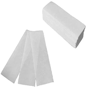 Stack of white nonwoven waxing paper strips for professional hair removal.