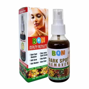 A jar of BON Organic Dark Spot Remover surrounded by fresh green leaves.