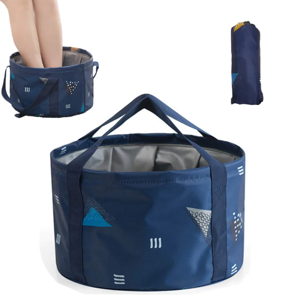 Dark blue portable travel foot basin standing upright filled with warm water at a campsite