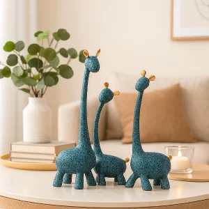 A three-piece Blue Giraffe Family Statue set displayed elegantly on a modern wooden console table.